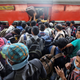 Migrant workers and their families board an overcrowded passenger train, after government imposed restrictions on public gatherings in attempts to prevent spread of coronavirus disease, in Mumbai